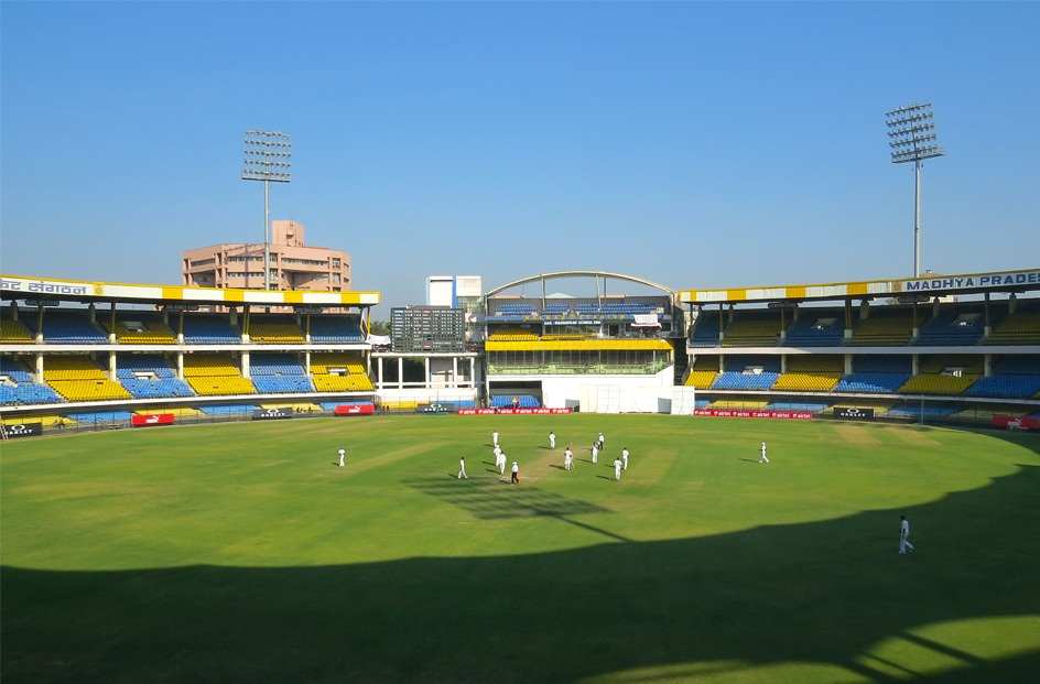 A test match is going on, at world 2nd smallest cricket stadium by boundary i.e. Holkar stadium during morning.